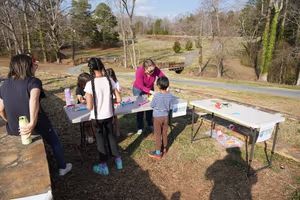 Instructor helping kids build rockets at a park