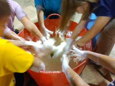 Kids plunging their hands into a big tub of oobleck