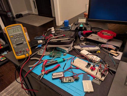 Electronics workbench with breadboards, microcontrollers, and wiring in progress