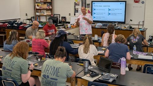 Quincy teaching the five-step solder joint to a classroom of Woodstock High School teachers, each at a lab bench with their own soldering station