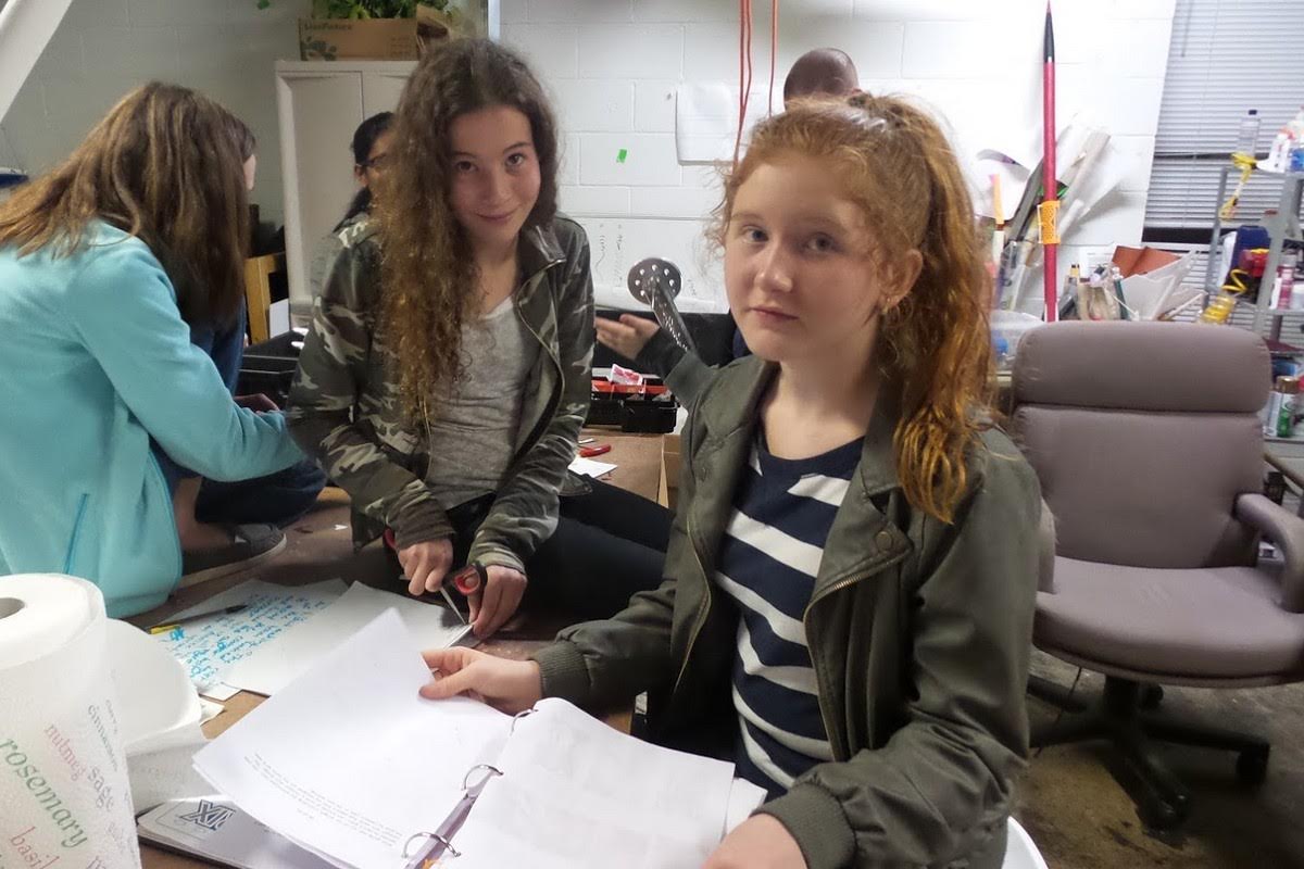 Group of girls collaborating on a robotics project in a makerspace, working together on building and programming